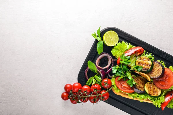 Bruschetta ızgara sebze, zeytin, otlar ve parmesan peyniri ekmeğin. Soğuk aperatifler. İtalyan mutfağı. Ahşap arka plan üzerinde.