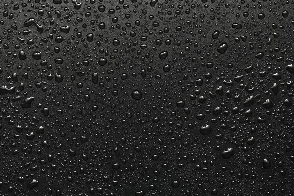 Капли воды на черной поверхности — стоковое фото