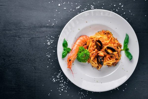 Deniz ürünleri makarna. Midye, karides. Ahşap bir arka plan üzerinde. Üstten Görünüm. Metniniz için boş alan.