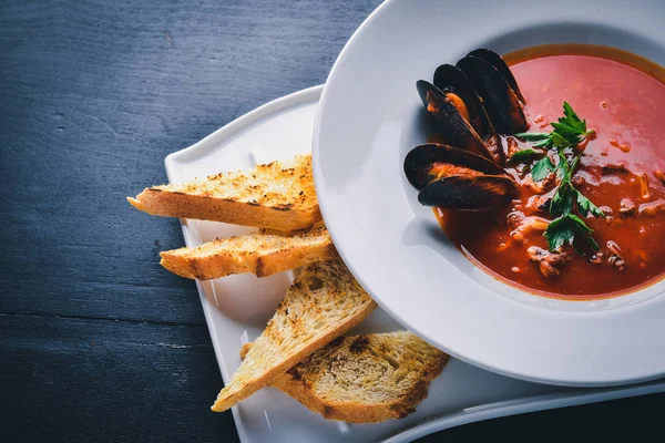 Midye ile krem çorbası domates ve deniz ürünleri. Ahşap bir arka plan üzerinde. Üstten Görünüm. Metniniz için boş alan.