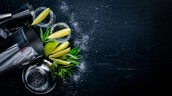 Kireç ve buz, siyah ahşap yüzeye tekila. Üstten Görünüm. Boş alan.