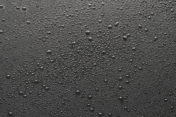 Wassertropfen auf schwarzer Oberfläche — Stockfoto