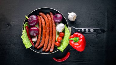 bir tavada ızgara sosis