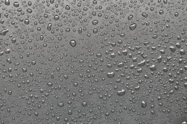 Siyah bir yüzeye düşen su damlaları