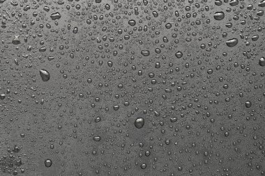 Siyah bir yüzeye düşen su damlaları