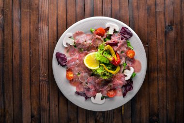 Carpaccio sığır eti, sebze, peynir, baharatlar, ahşap arka plan için. Üstten Görünüm. Boş alan