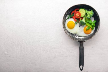 Sahanda yumurta ile bir tavada sebze ve otlar. Üstten Görünüm. Boş alan.