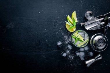 Limon ve nane kokteyli, buz, siyah ahşap yüzeye. Üstten Görünüm. Boş alan.