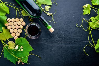 Üzüm cinayet sebebi. Bir şişe, bir bardak şarap ve üzüm yaprakları. Üstten Görünüm. Boş alan.