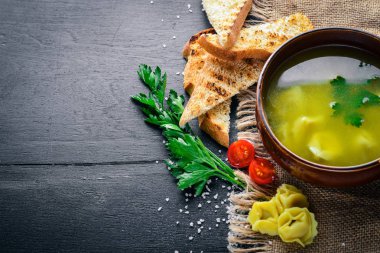 Suyu mantı ve otlar. İtalyan mutfağı. Ahşap bir arka plan üzerinde. Üstten Görünüm. Metniniz için boş alan.