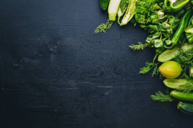 Büyük bir set bir ahşap zemin üzerine yeşil sebze. Üstten Görünüm. Boş alan.