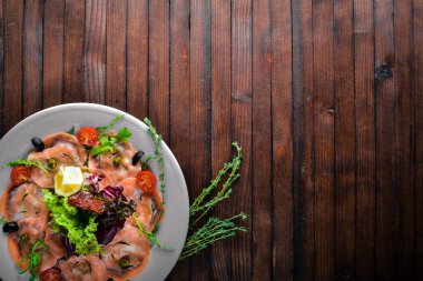 Carpaccio balık, sebze, peynir, baharatlar, ahşap arka plan için. Üstten Görünüm. Boş alan.