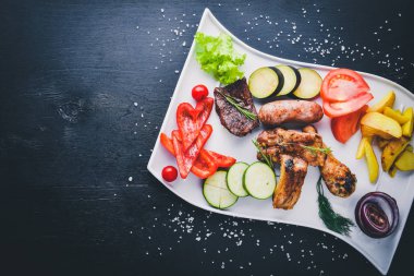 Çeşitli ızgara et ve sebze dilimlenmiş. Ahşap bir arka plan üzerinde. Üstten Görünüm. Metniniz için boş alan.