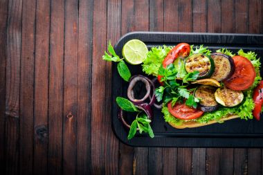 Bruschetta ızgara sebze, zeytin, otlar ve parmesan peyniri ekmeğin. Soğuk aperatifler. İtalyan mutfağı. Ahşap arka plan üzerinde.