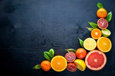 Taze narenciye. Limon portakal, mandalina, limon. Bir siyah arka plan üzerine tahta. Üstten Görünüm.
