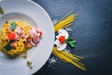 Kremalı sos pastırma ile makarna. Geleneksel İtalyan yemekleri. Ahşap bir arka plan üzerinde. Üstten Görünüm. Metniniz için boş alan.