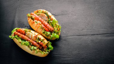 Sosis ızgara sosis, hardal ve ketçap, soğan ve Yeşiller ahşap arka plan üzerinde. Üstten Görünüm. Boş alan.