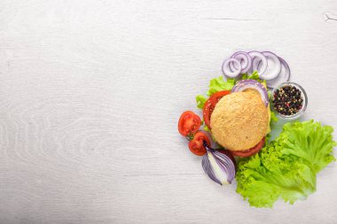 Peynir, et, domates ve soğan ve otlar ile hamburger. Ahşap arka plan üzerinde. Üstten Görünüm. Boş alan.