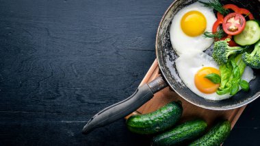 Sahanda yumurta ile bir tavada sebze ve otlar. Üstten Görünüm. Boş alan.