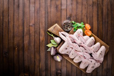 Baharat ile çiğ tavuk kanatları. Ahşap yüzeyde. Üstten Görünüm.