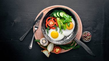 Sahanda yumurta ile bir tavada sebze ve otlar. Üstten Görünüm. Boş alan.