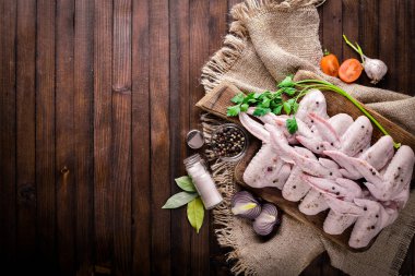 Baharat ile çiğ tavuk kanatları. Ahşap yüzeyde. Üstten Görünüm.