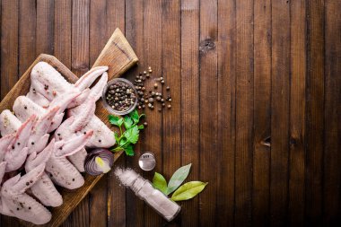 Baharat ile çiğ tavuk kanatları. Ahşap yüzeyde. Üstten Görünüm.