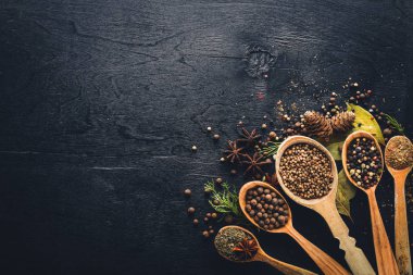 Güzel kokulu baharatlar kümesi. Siyah ve kırmızı biber, kişniş, kırmızı biber karışımı. Ahşap arka plan üzerinde. Üstten Görünüm. Boş alan.