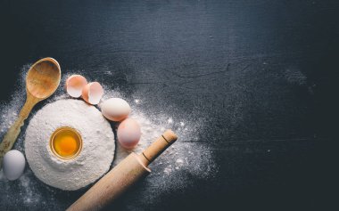 Pişirme için hazırlık. Bir oklava ile yumurta. Taş masanın üstünde. Metin için özgür yer. Üstten Görünüm.