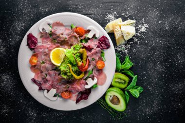 Carpaccio sığır eti, sebze, peynir, baharatlar, ahşap arka plan için. Üstten Görünüm. Boş alan