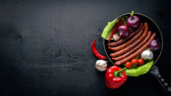 bir tavada ızgara sosis