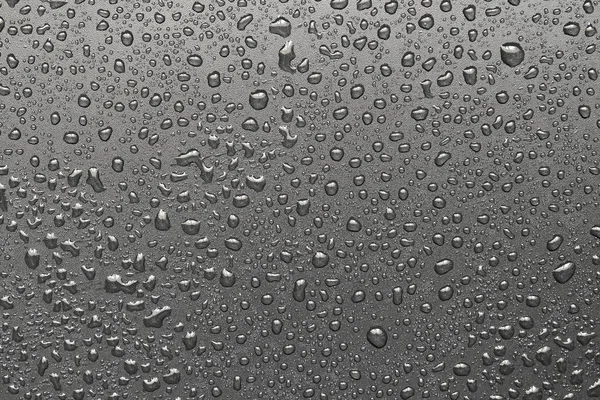 Gotas de água em uma superfície preta — Fotografia de Stock