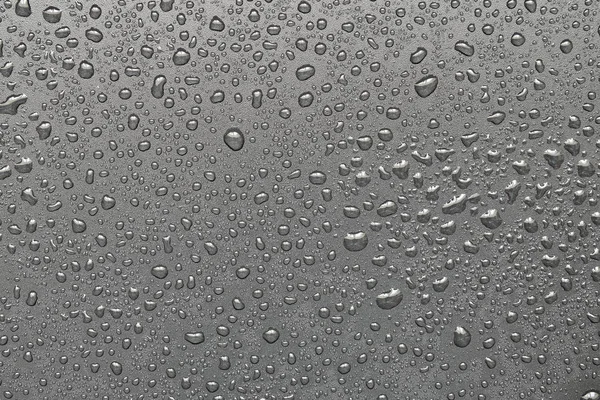 Siyah bir yüzeye düşen su damlaları