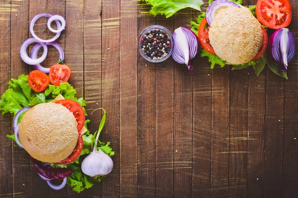 Peynir, et, domates ve soğan ve otlar ile hamburger. Ahşap arka plan üzerinde. Üstten Görünüm. Boş alan.