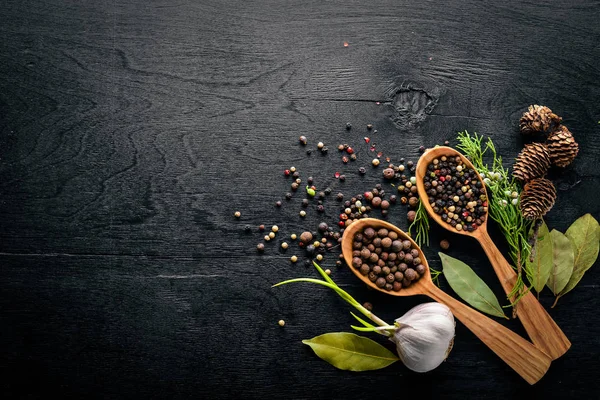 Güzel kokulu baharatlar kümesi. Siyah ve kırmızı biber, kişniş, kırmızı biber karışımı. Ahşap arka plan üzerinde. Üstten Görünüm. Boş alan.