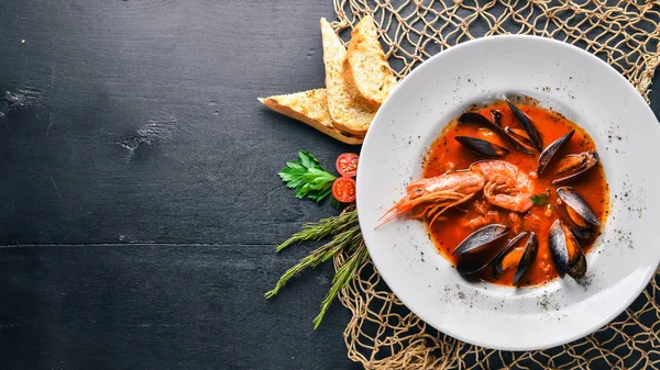 Mussels and tiger prawns in tomato sauce. Italian traditional food. On a wooden background. Top view. Free space for your text. — Stock Photo, Image