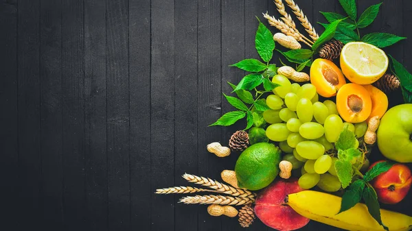 Siyah ahşap bir masa üzerine taze meyve büyük kümesi. Metniniz için boş alan. Üstten Görünüm.