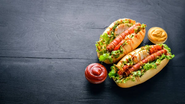 Sosis ızgara sosis, hardal ve ketçap, soğan ve Yeşiller ahşap arka plan üzerinde. Üstten Görünüm. Boş alan.