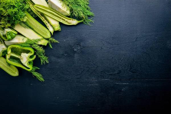 Büyük bir set bir ahşap zemin üzerine yeşil sebze. Üstten Görünüm. Boş alan.