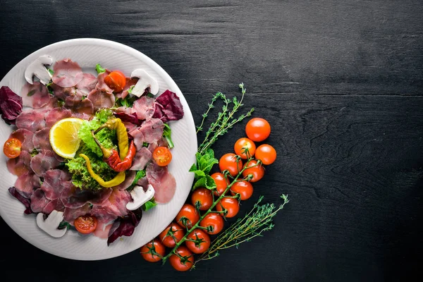 Carpaccio sığır eti, sebze, peynir, baharatlar, ahşap arka plan için. Üstten Görünüm. Boş alan