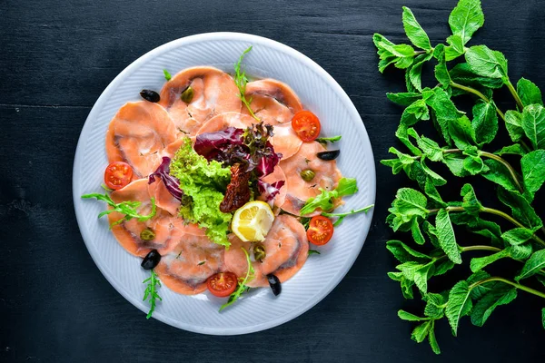 Carpaccio balık, sebze, peynir, baharatlar, ahşap arka plan için. Üstten Görünüm. Boş alan.