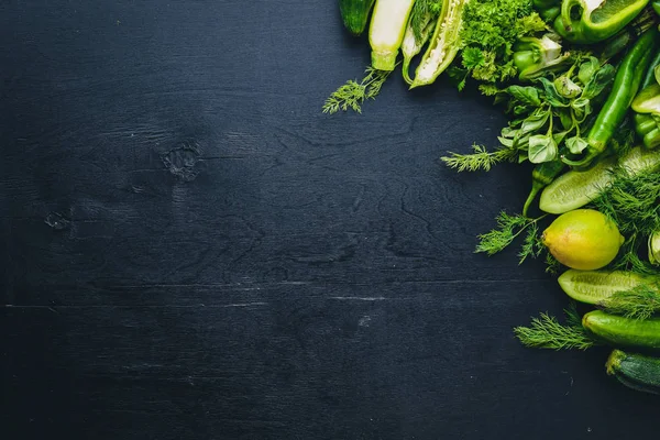 Büyük bir set bir ahşap zemin üzerine yeşil sebze. Üstten Görünüm. Boş alan.