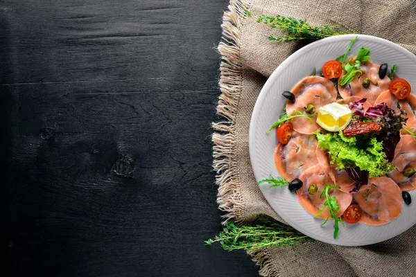 Carpaccio balık, sebze, peynir, baharatlar, ahşap arka plan için. Üstten Görünüm. Boş alan.