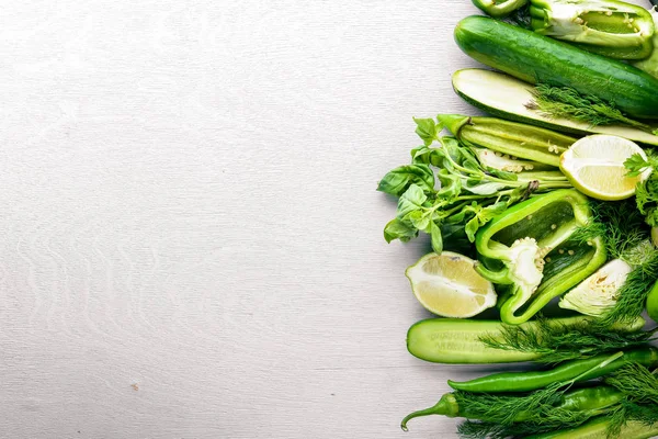 Büyük bir set bir ahşap zemin üzerine yeşil sebze. Üstten Görünüm. Boş alan.