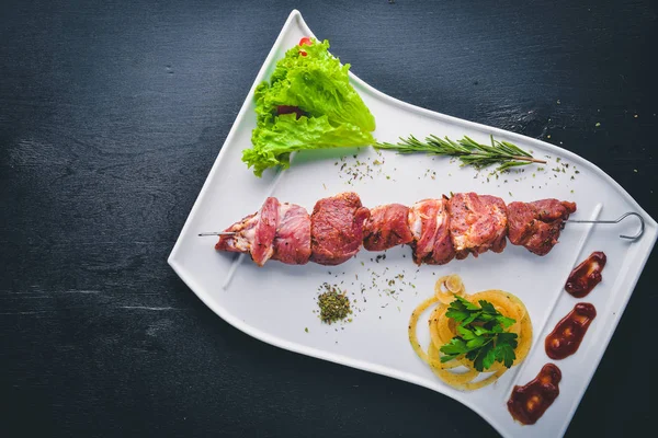 Ahşap arka plan üzerinde ham şiş kebap. Üstten Görünüm. Metniniz için boş alan.