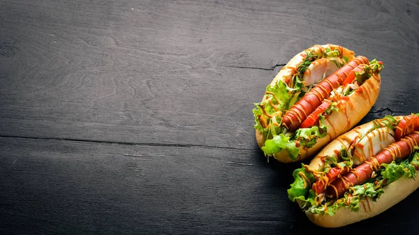 Sosis ızgara sosis, hardal ve ketçap, soğan ve Yeşiller ahşap arka plan üzerinde. Üstten Görünüm. Boş alan.