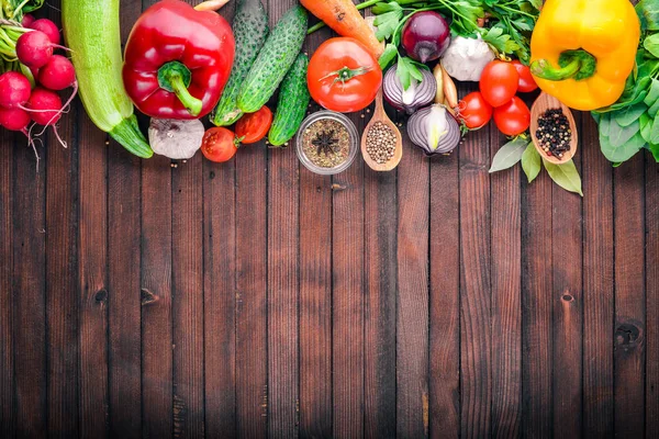 Keret bioélelmiszerek. Friss nyers zöldségek és fűszerek. A fából készült chalkboard. — Stock Fotó