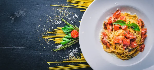 Makarna domates. Geleneksel İtalyan yemekleri. Ahşap bir arka plan üzerinde. Üstten Görünüm. Metniniz için boş alan.