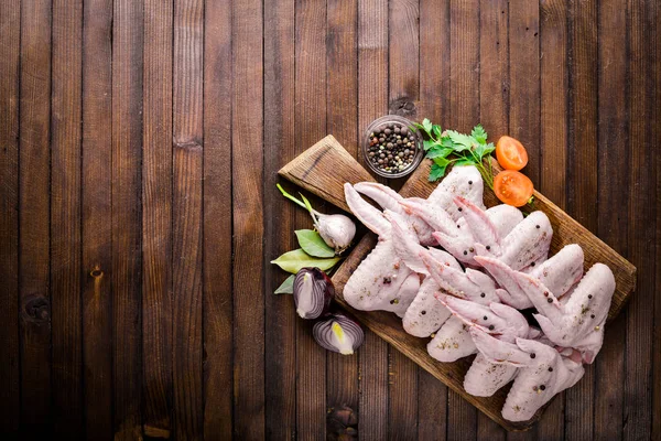 Baharat ile çiğ tavuk kanatları. Ahşap yüzeyde. Üstten Görünüm.