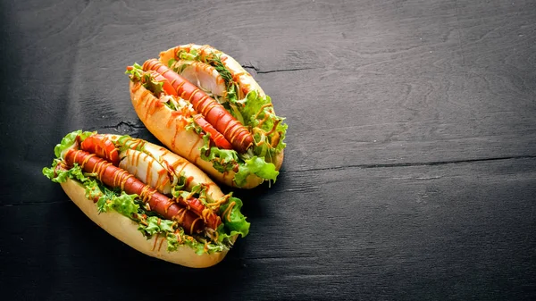 Sosis ızgara sosis, hardal ve ketçap, soğan ve Yeşiller ahşap arka plan üzerinde. Üstten Görünüm. Boş alan.